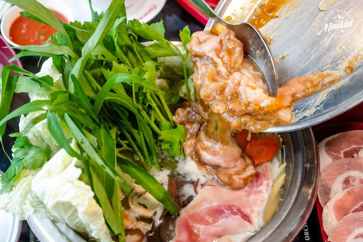 ภาพโคลสอัปแอ็กชันขณะเทชุดเนื้อหมักตอกไข่สูตรโบราณ เมนูซิกเนเจอร์ของเรือนเพชรสุกี้ ลงในหม้อไฟที่กำลังเดือดพล่าน อัดแน่นไปด้วยผักสดและหมูสไลซ์ สื่อถึงความอร่อยและกลิ่นอายสุกี้ต้นตำรับ
