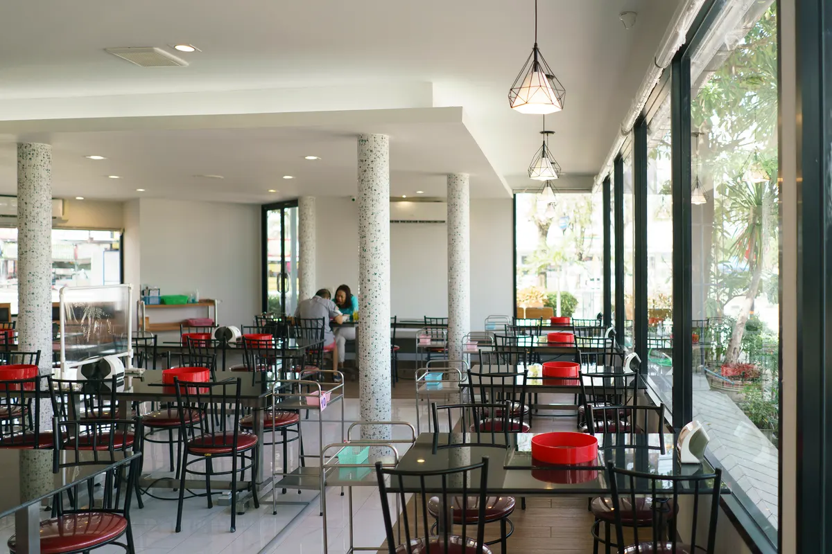 บรรยากาศช่วงกลางวันภายในเรือนเพชรสุกี้ สาขาเลี่ยงเมืองนนทบุรี ร้านกว้างขวางและสว่างไสวด้วยแสงธรรมชาติจากกระจกบานใหญ่ที่มองเห็นวิวถนนด้านนอก พร้อมโซนโต๊ะอาหารสไตล์โมเดิร์นจัดเตรียมไว้อย่างเป็นระเบียบ และมีลูกค้ากำลังนั่งรับประทานอาหาร